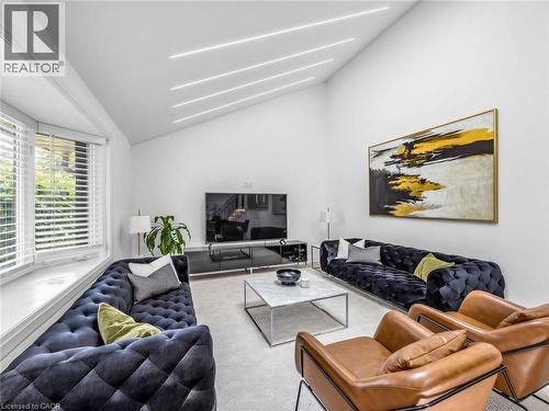 Spacious living area featuring a vaulted ceiling with linear lighting, a large bay window, and light-toned wall-to-wall carpeting - 13 Swanhurst Boulevard, Mississauga, ON 