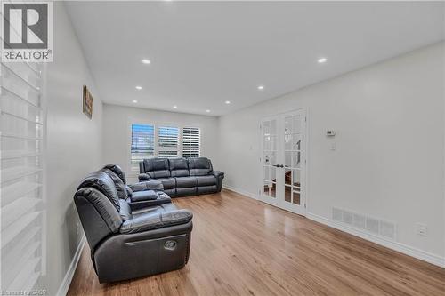 Bright living area featuring wood-finish flooring, recessed lighting, and white walls - 191 Stirling Macgregor Drive, Cambridge, ON 