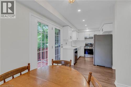 Kitchen featuring white cabinetry, stainless steel appliances, and wood-finish flooring - 191 Stirling Macgregor Drive, Cambridge, ON 