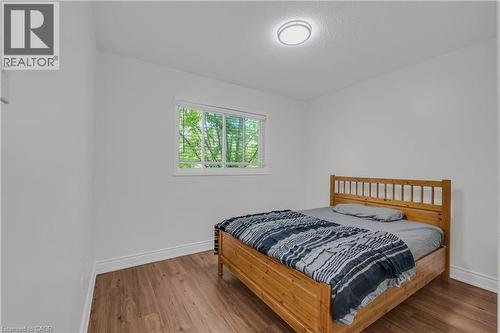 Bedroom featuring wood-finish flooring, white walls, and a large window with white blinds - 191 Stirling Macgregor Drive, Cambridge, ON 