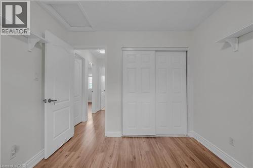 Interior room featuring wood-finish flooring, white walls, and a white sliding closet door - 191 Stirling Macgregor Drive, Cambridge, ON 