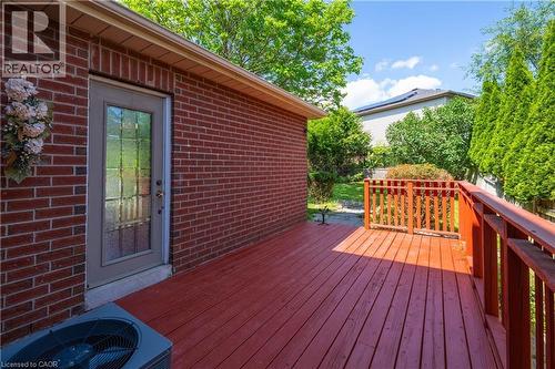 Expansive wood-finish deck with a red stain and a matching railing system - 191 Stirling Macgregor Drive, Cambridge, ON 