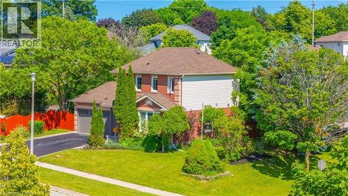Brick and siding exterior featuring a multi-gabled roofline, attached two-car garage, paved driveway, and mature landscaping - 191 Stirling Macgregor Drive, Cambridge, ON 