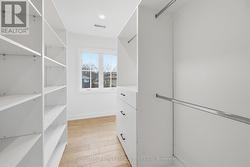 Walk-In Primary Closet with Built-Ins and Window - 
