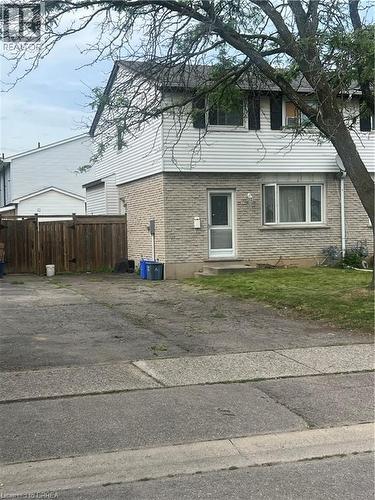 Two-story residential structure featuring a light brick facade on the lower level and white horizontal siding on the upper level - 35 Debby Crescent, Brantford, ON 