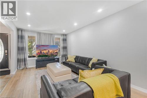 Living area featuring recessed ceiling lighting, light-tone wood-finish flooring, and a decorative front entry door with an oval-shaped glass insert - 23 Millpond Place, Mountain, ON 