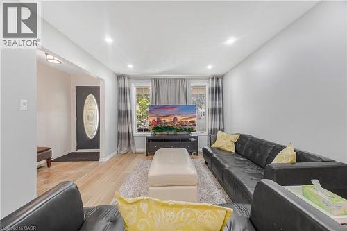 Bright living area featuring recessed lighting, wood-finish flooring, and white painted walls - 23 Millpond Place, Mountain, ON 