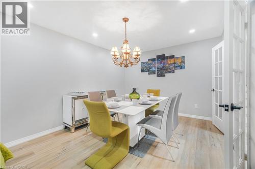 Dining area featuring a decorative chandelier, recessed lighting, and wood-finish flooring - 23 Millpond Place, Mountain, ON 