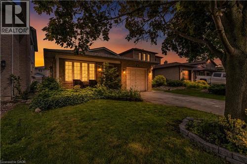 Brick facade residence featuring a front bay window, attached garage, and a concrete driveway - 23 Millpond Place, Mountain, ON 