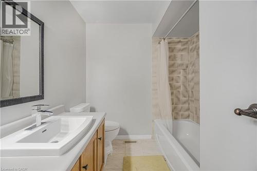 Bathroom vanity featuring a rectangular undermount sink, chrome faucet, and wood-finish cabinetry - 23 Millpond Place, Mountain, ON 