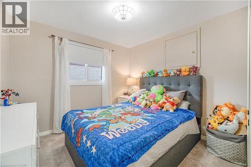 Carpeted room featuring a window with white blinds and sheer curtains, a semi-flush mount ceiling light, and a built-in access panel - 23 Millpond Place, Mountain, ON 