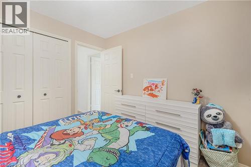 Bedroom featuring neutral wall color, white trim, and white bi-fold closet doors - 23 Millpond Place, Mountain, ON 