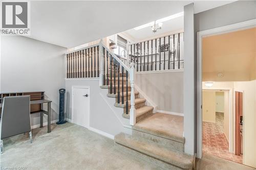 Carpeted staircase with white risers and dark wood balusters - 23 Millpond Place, Mountain, ON 