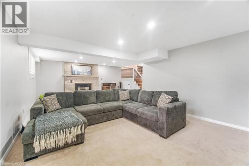 Carpeted recreation room featuring a brick fireplace with a mantel, recessed lighting, and a window with white louvered blinds - 23 Millpond Place, Mountain, ON 