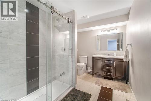 Full bathroom featuring a shower-tub combination with sliding glass doors and tiled surround - 23 Millpond Place, Mountain, ON 