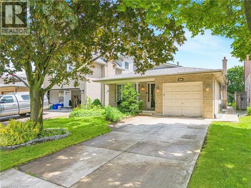 Stone-clad facade with an attached garage and covered front entry - 23 Millpond Place, Mountain, ON 