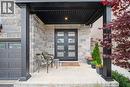 Stone facade with a covered porch featuring black support columns and a dark paneled ceiling - 130 Pondcliffe Drive, Kitchener, ON 