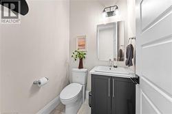 Contemporary vanity featuring a white countertop and dark cabinetry - 