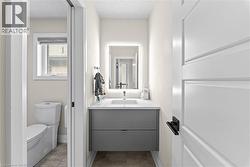 Modern powder room featuring a floating gray vanity with a white countertop and rectangular sink - 