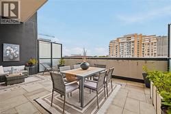 Expansive outdoor terrace featuring large format tile flooring, a dark exterior wall, and an open-air perimeter - 