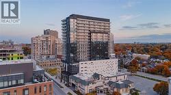 Contemporary high-rise building featuring a sleek glass facade and multiple balconies - 