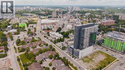 Aerial perspective showcasing a modern high-rise building with a distinctive grey and green facade, surrounded by urban infrastructure and residential areas - 