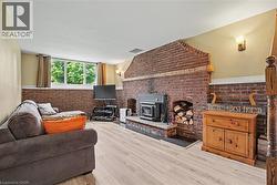 Brick fireplace with integrated wood-burning stove and firewood storage niche - 