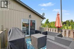Expansive outdoor deck featuring wood flooring, a sliding glass door entry, and a wood privacy fence - 