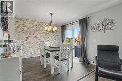 Dining area with a stone-accented wall and wood-finish flooring - 