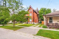 Red brick exterior featuring a steeply pitched roofline, arched window details, and an exterior staircase - 