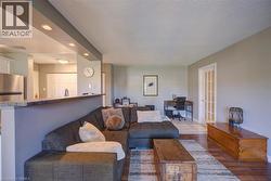 Open-concept living space featuring wood-finish flooring, recessed lighting, and a white paneled door with glass inserts - 