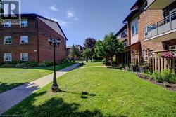 Brick exterior apartment buildings surrounding a grassy courtyard with concrete pathways - 