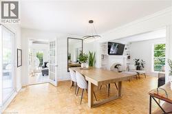 Spacious interior featuring parquet wood-finish flooring, French doors, a built-in fireplace with shelving, abundant natural light, and crown molding - 