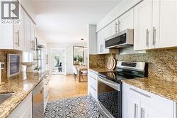 Kitchen featuring white cabinetry, granite countertops, and a patterned tile floor - 