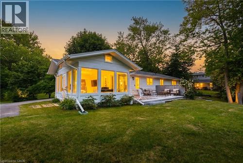 Ranch-style residence featuring an expansive sunroom with abundant windows, a spacious backyard, and a multi-level outdoor deck - 176 Riverbank Drive, Cambridge, ON 