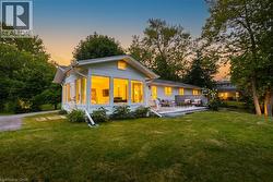 Ranch-style residence featuring an expansive sunroom with abundant windows, a spacious backyard, and a multi-level outdoor deck - 