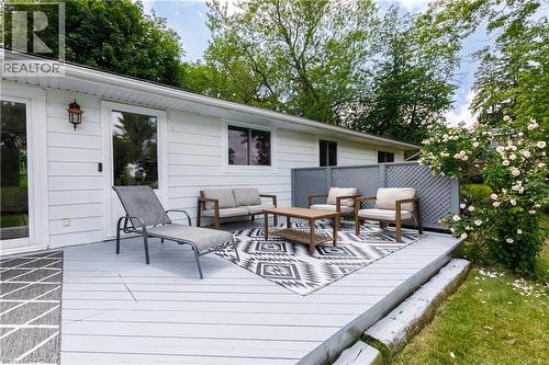 Spacious outdoor deck featuring gray wood-finish decking, decorative lattice privacy screen, and white siding - 176 Riverbank Drive, Cambridge, ON 