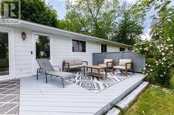 Spacious outdoor deck featuring gray wood-finish decking, decorative lattice privacy screen, and white siding - 