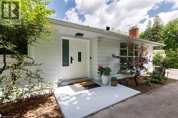 White siding exterior featuring a prominent entry door with opaque glass inserts and black hardware - 