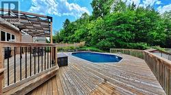 Expansive wood deck surrounding a blue swimming pool - 