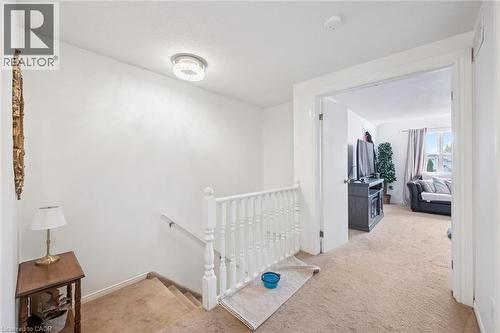 Staircase with white balusters and carpeted treads, leading to a carpeted landing - 765 Angler Way, Waterloo, ON 
