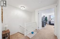 Staircase with white balusters and carpeted treads, leading to a carpeted landing - 