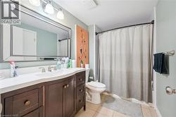 Bathroom featuring a dark wood vanity with a white countertop and integrated sink - 