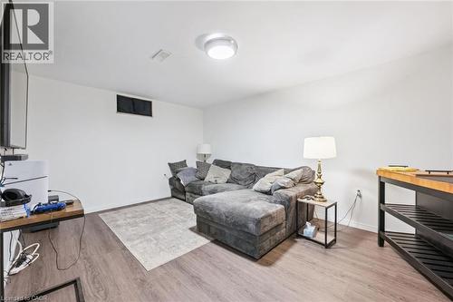 Living area featuring wood-finish flooring, white walls, and an overhead flush-mount light fixture - 765 Angler Way, Waterloo, ON 