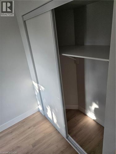 Closet featuring sliding doors, integrated shelving, and a hanging rod - 3085 Kingsway Drive Unit# 21, Kitchener, ON 