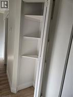 Built-in corner shelving unit with three white shelves - 