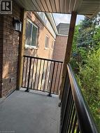 Private balcony featuring a concrete surface, black metal railing, and a light-colored soffit - 