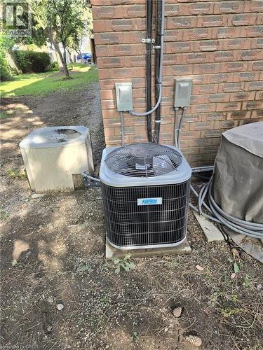 Exterior brick wall with two outdoor HVAC units - 3085 Kingsway Drive Unit# 21, Kitchener, ON 