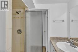 Shower enclosure with frosted glass door, complemented by a tiled shower surround and a chrome shower head - 