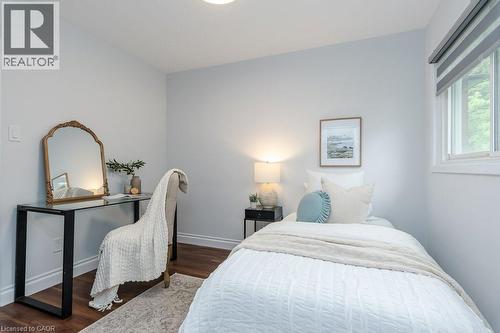 Bright bedroom featuring wood-finish flooring, light-colored walls, and a window with blinds - 139 Mackay Crescent, Waterloo, ON 